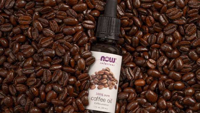 Coffee beans surrounding NOW Coffee Oil bottle