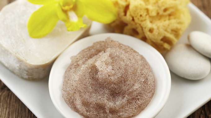 A small dish on a white platter holds Calming Sugar Body Scrub