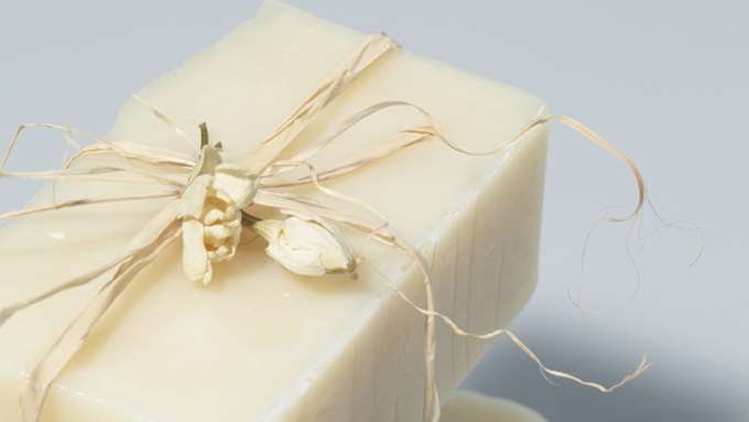A closeup of a Luxurious Lotion Bar against a grey background