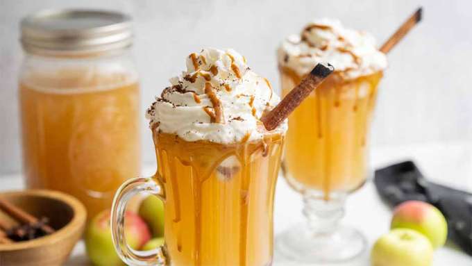 three glasses of Cozy Caramel Apple Cider with Whipped Cream and Cinnamon