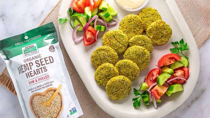 top view of High Protein Baked Falafel Patties next to a bag of NOW Hemp Heart Seeds