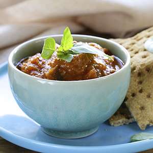 A small ceramic bowl is filled with Curried Eggplant