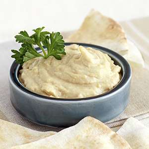 A small, grey dipping bowl filled with Hummus
