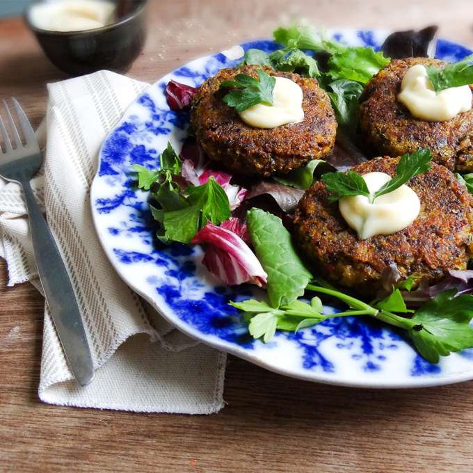 A white ceramic plate with blue floral decorations holds several Winter Squash & Quinoa Rissoles