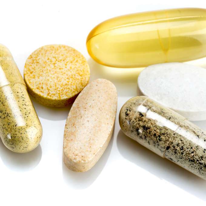 group of tablets and capsules on a white background