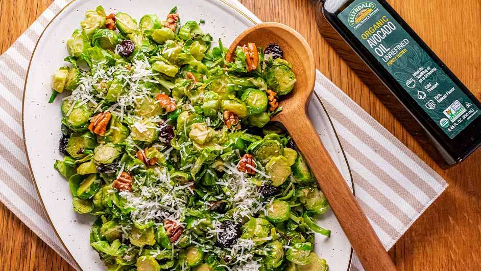 top view of Warm Brussels Sprouts Salad next to a bottle of ellyndale avocado oil
