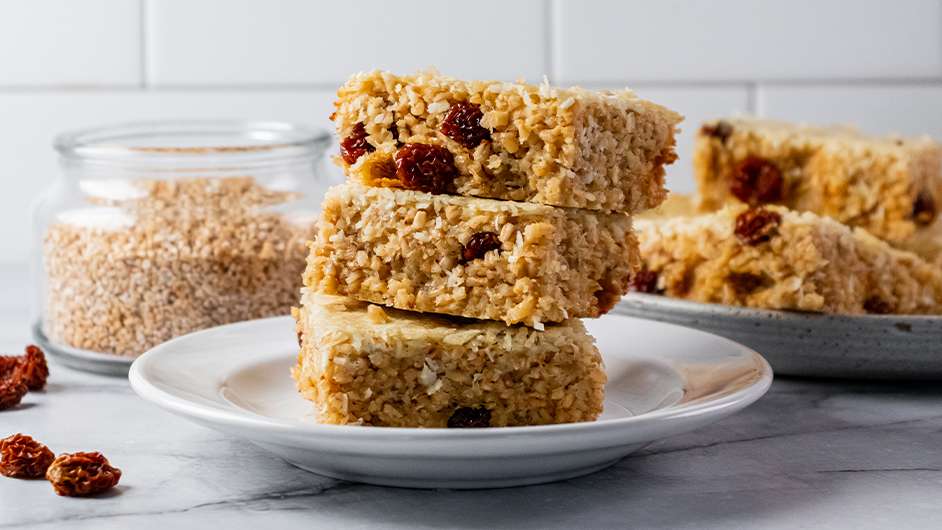 white plate with a stack of three golden berry and coconut oat bars on them