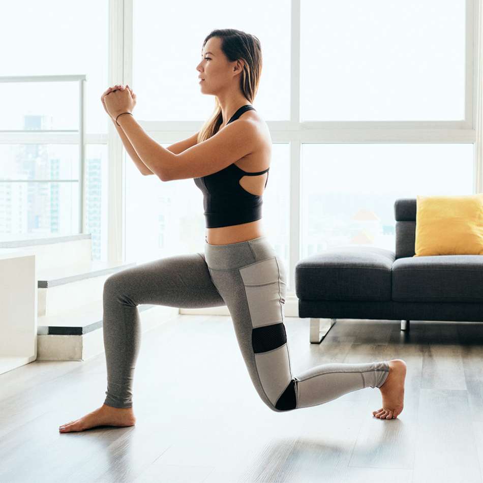 light skinned, female presenting person in living room doing a lung exersize