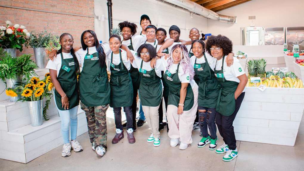 group of diverse young people in green aprons posing for a photo for By the Hand Club for Kids